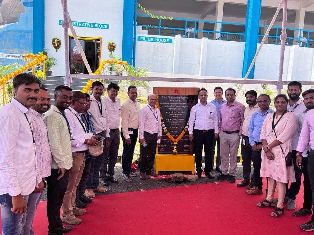The Gondwana Engineers project team beside the commissioning plaque at the PCMC 100 MLD water treatment plant, with the administrative block and filter house behind