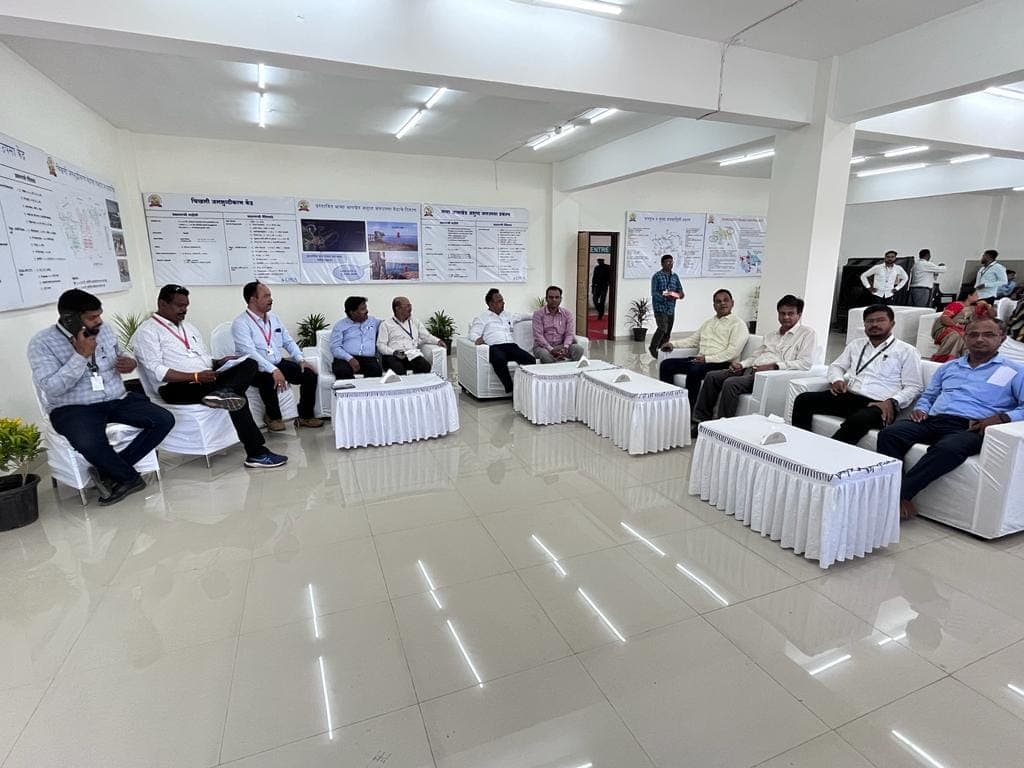 Officials gathered in the administrative block lobby of the PCMC 100 MLD water treatment plant, with project information displays on the walls