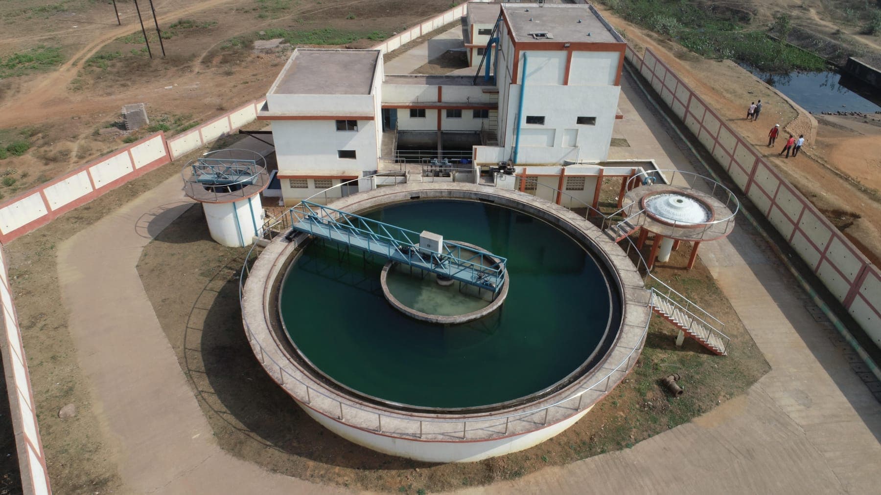 Circular clarifier with central rotating bridge mechanism beside the control building at the SAIL Bhilai tertiary treatment plant