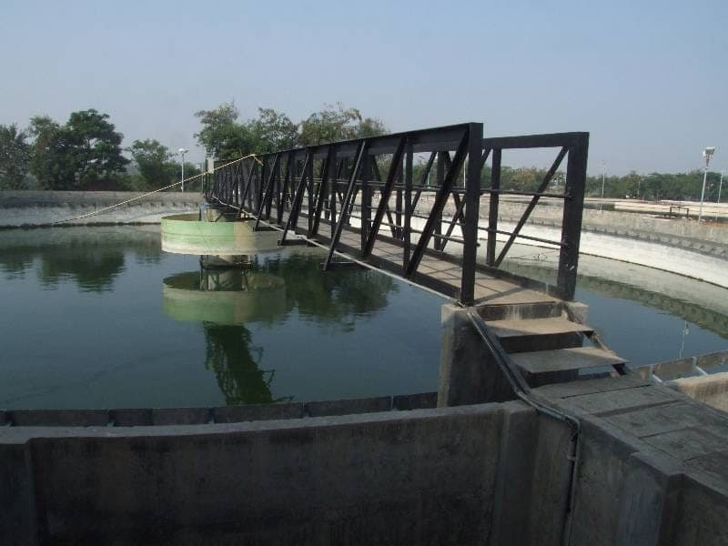 Circular clarifier with a steel-truss rotating-bridge scraper mechanism spanning the tank at the Tapovan STP, Nashik